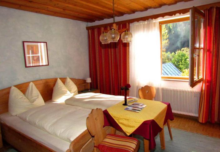 Gemütliches Zimmer mit zwei Betten, Fenster und Tisch in der Unterkunft Haus Brigitte.