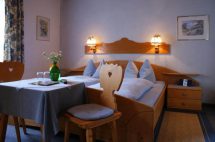 Gemütliches Zimmer im Haus Brigitte mit Doppelbett, Tisch und Stühlen, harmonischer Atmosphäre.